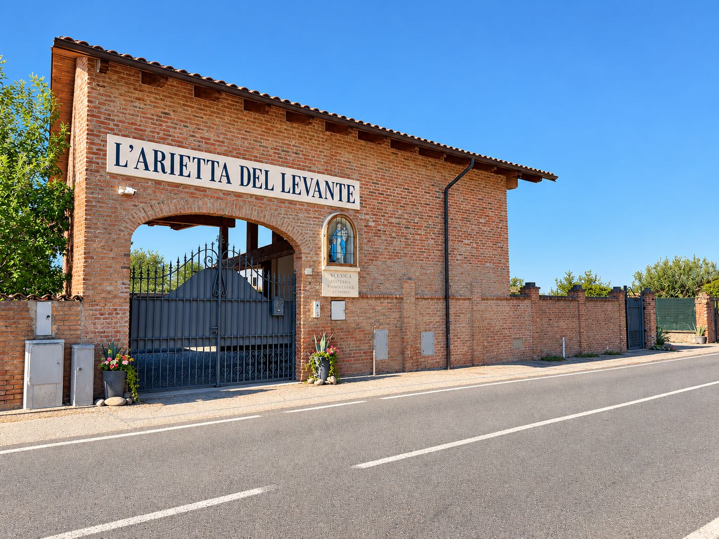 Il portale in mattoni della cascina con la scritta L'arietta del Levante