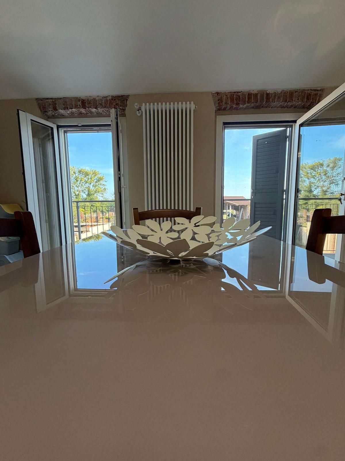 Tavolo da pranzo davanti alle portefinestre sul balcone